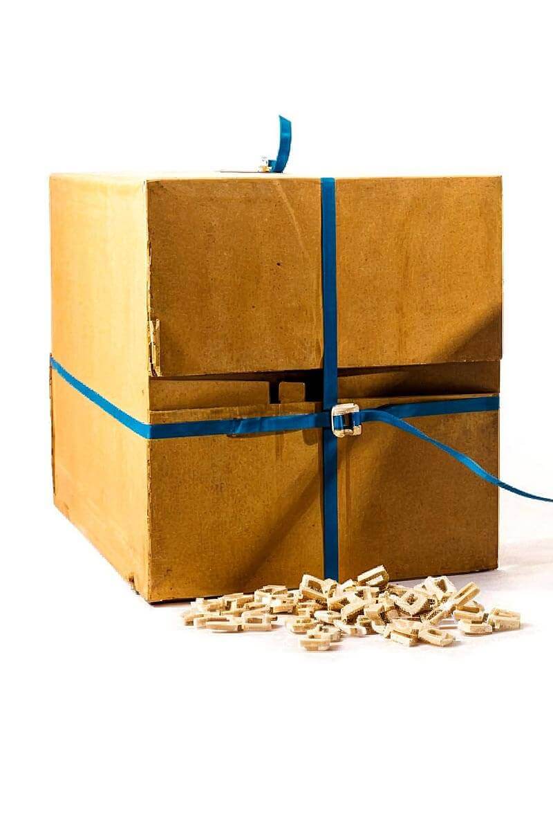 Caja de cartón asegurada con zuncho plástico azul y broches de sujeción